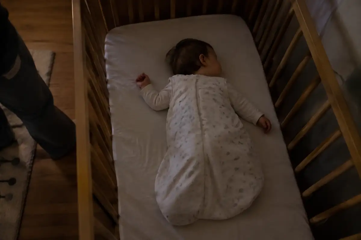 Bébé endormi sur le dos dans une gigoteuse, dans son lit sans couverture ni oreiller