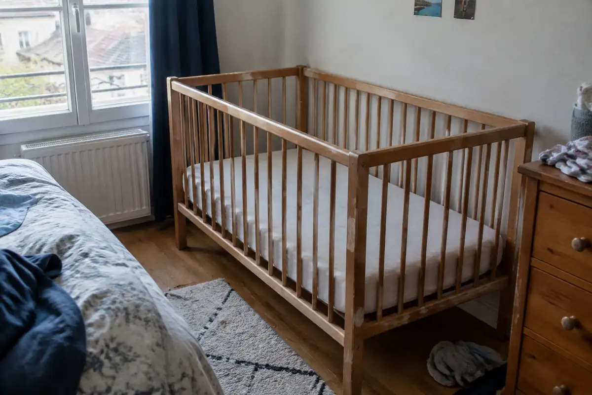 Un lit à barreaux dépouillé : un matelas ferme et rien d'autre à l'intérieur