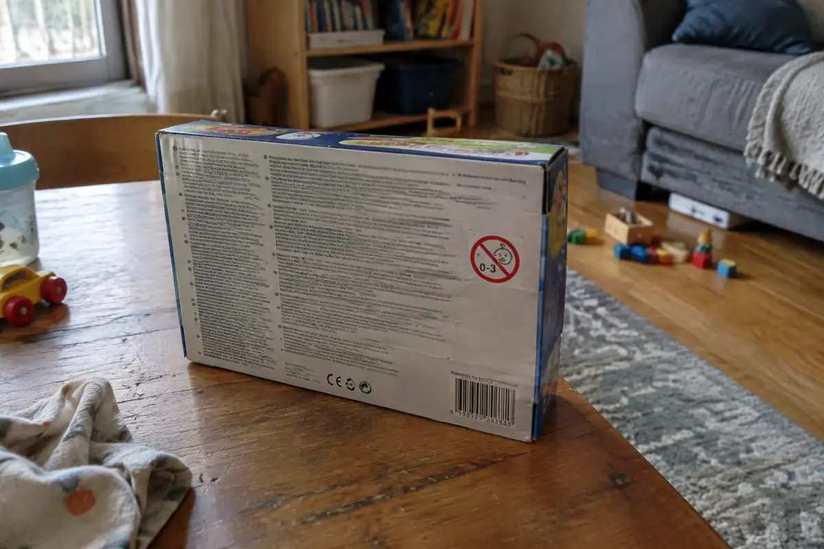 Dos d'une boîte de jouet avec un symbole rond barré illisible